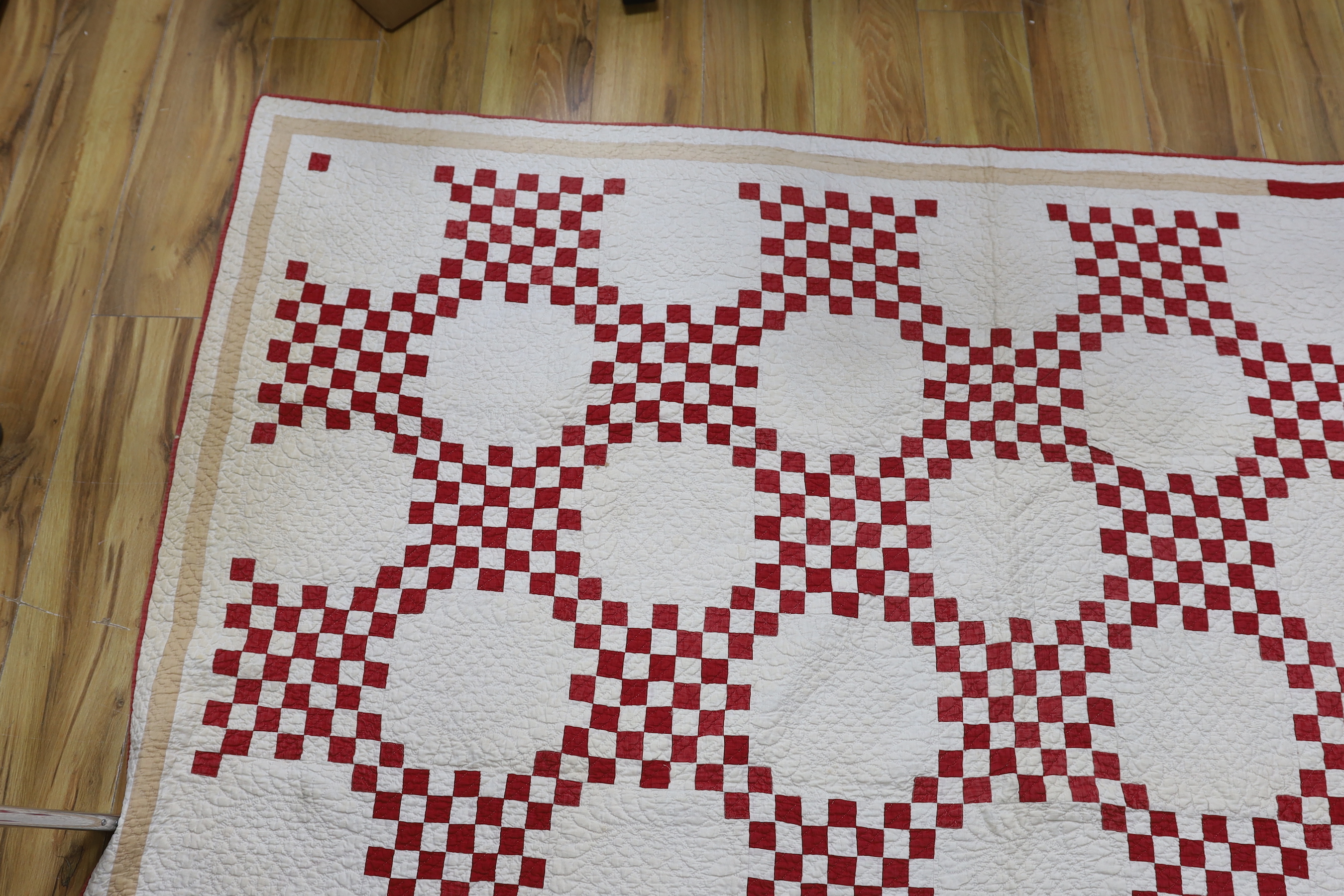 A 19th century Irish chain quilt with red and beige fabric on cream background American